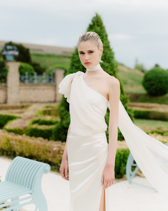 Elegant one-shoulder wedding dress with a train and a long bow