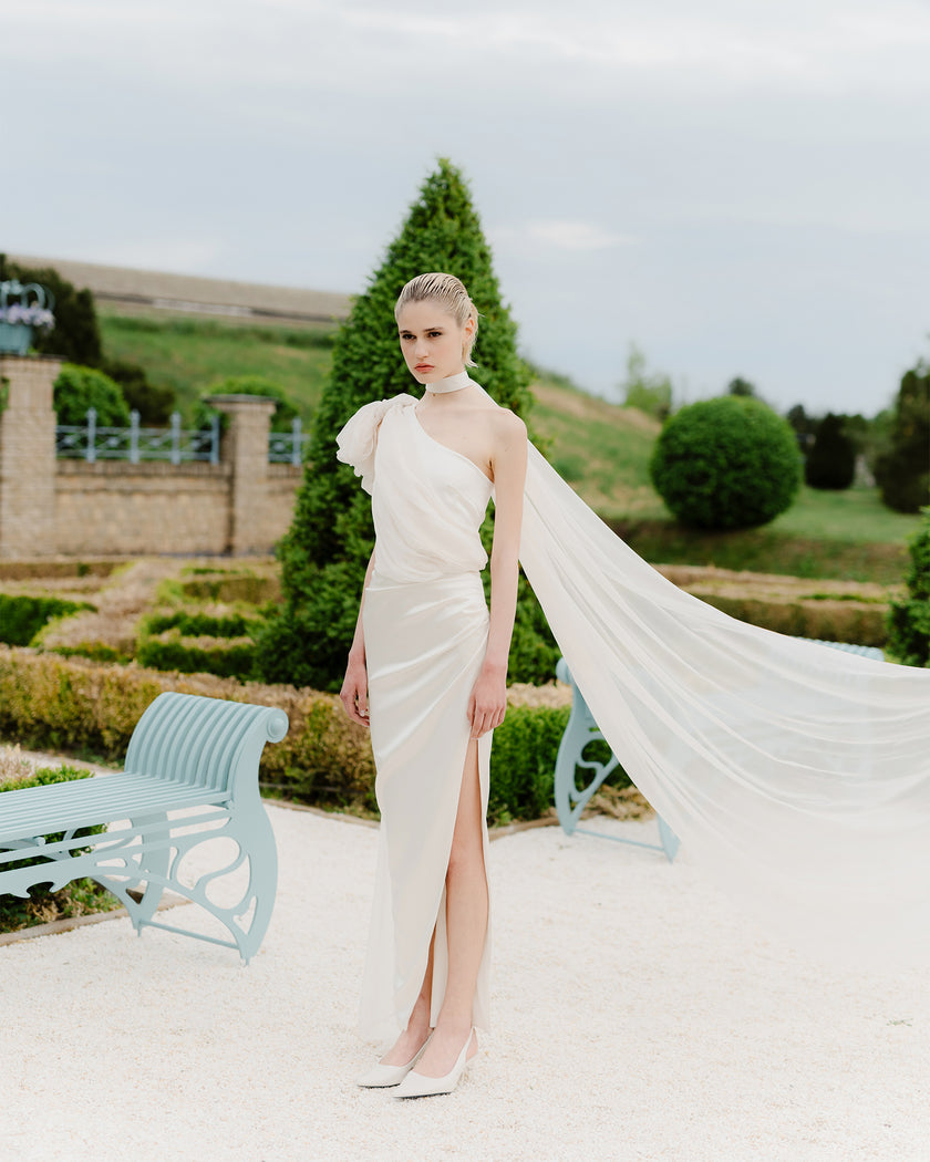 Elegant one-shoulder wedding dress with a train and a long bow