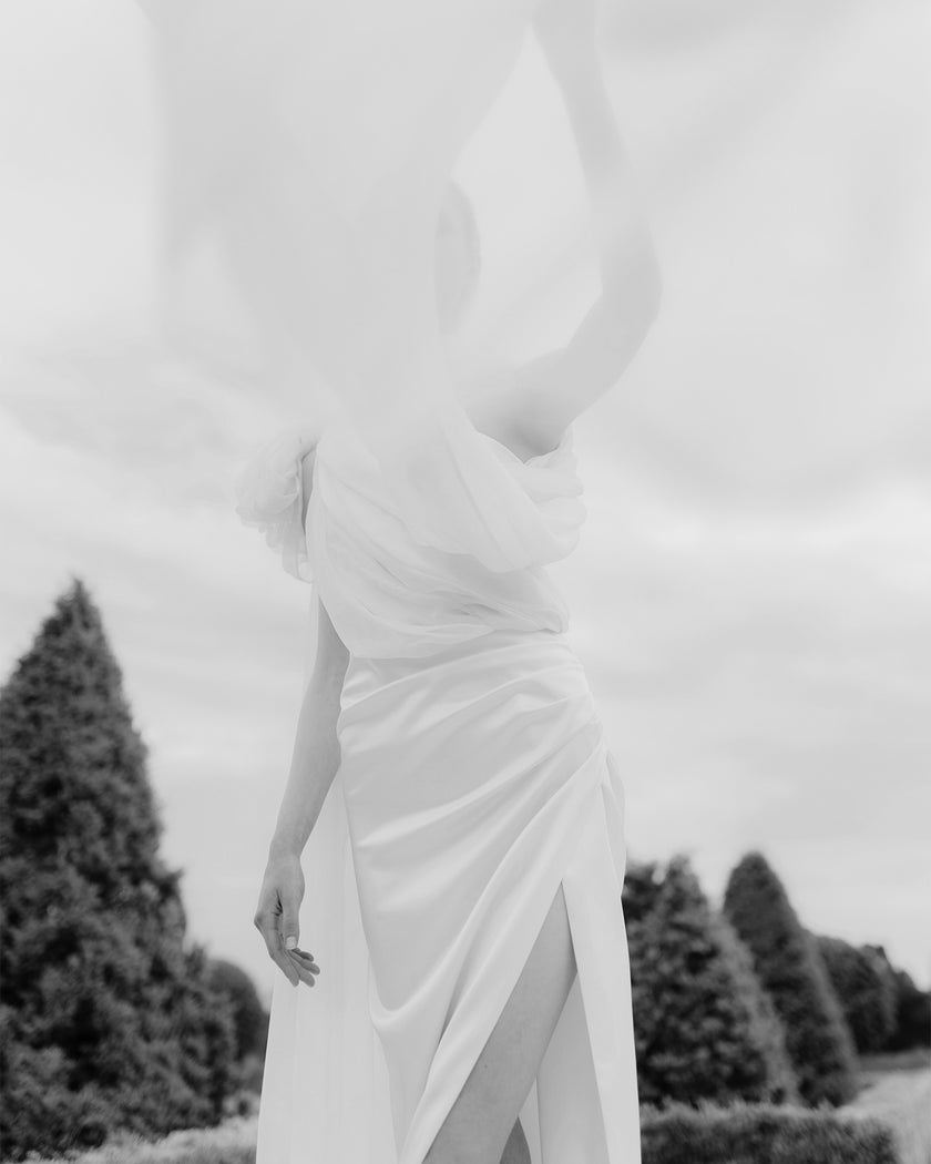 Elegant one-shoulder wedding dress with a train and a long bow